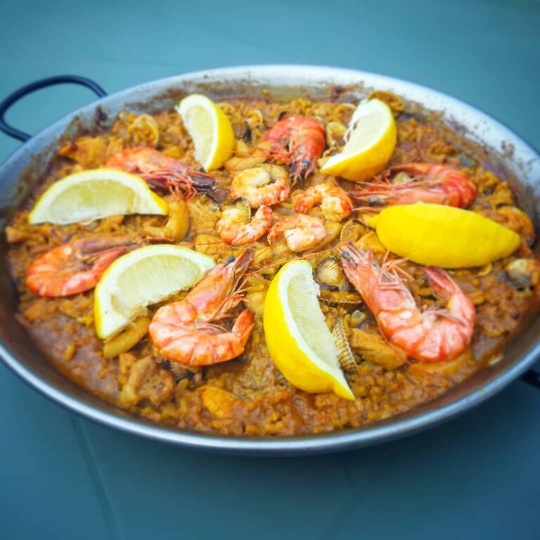 big paella pan: yellow rice with scampi and lemon parts on top