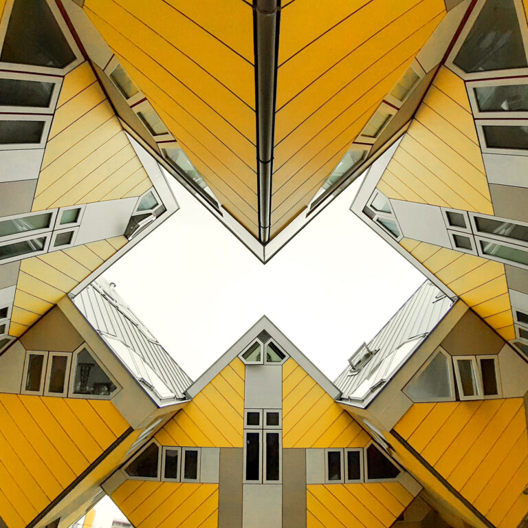 gelbe, übereinander gestapelte Kubushäuser mit Fenstern
