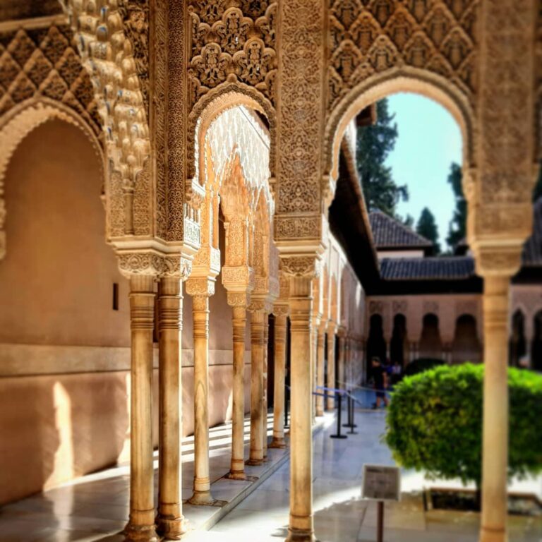 Innenhof der Alhambra in Granada mit Bögen, auf denen maurische Muster zu sehen sind